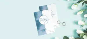 Romantische Hochzeitskarten als Einladungsarten für die Kirchliche Hochzeit, in Blau weiß auf blauem Tisch