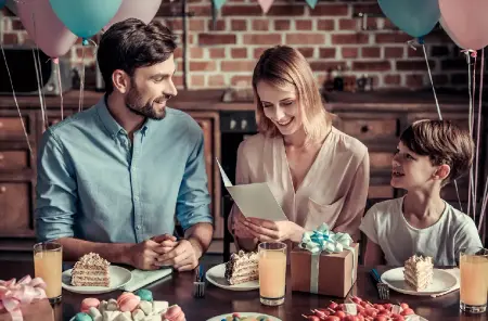 Familie mit Kind feiert Geburtstag rund, Mutter hält Klappkarte, Einladungskarten zum Geburtstag erstellen, Vorlage für Einladung und Einladungen runder Geburtstag, Farben warm und im Vintage Stil gehalten