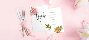 Platzkarten Hochzeit in weiß mit Blumen in Gold auf rosa Tisch neben Besteck