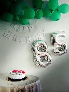 Silberne 85 als Luftballon mit grünen Luftballons im Hintergrund, als Design für Einladung zum runden Geburtstag oder Jubiläum