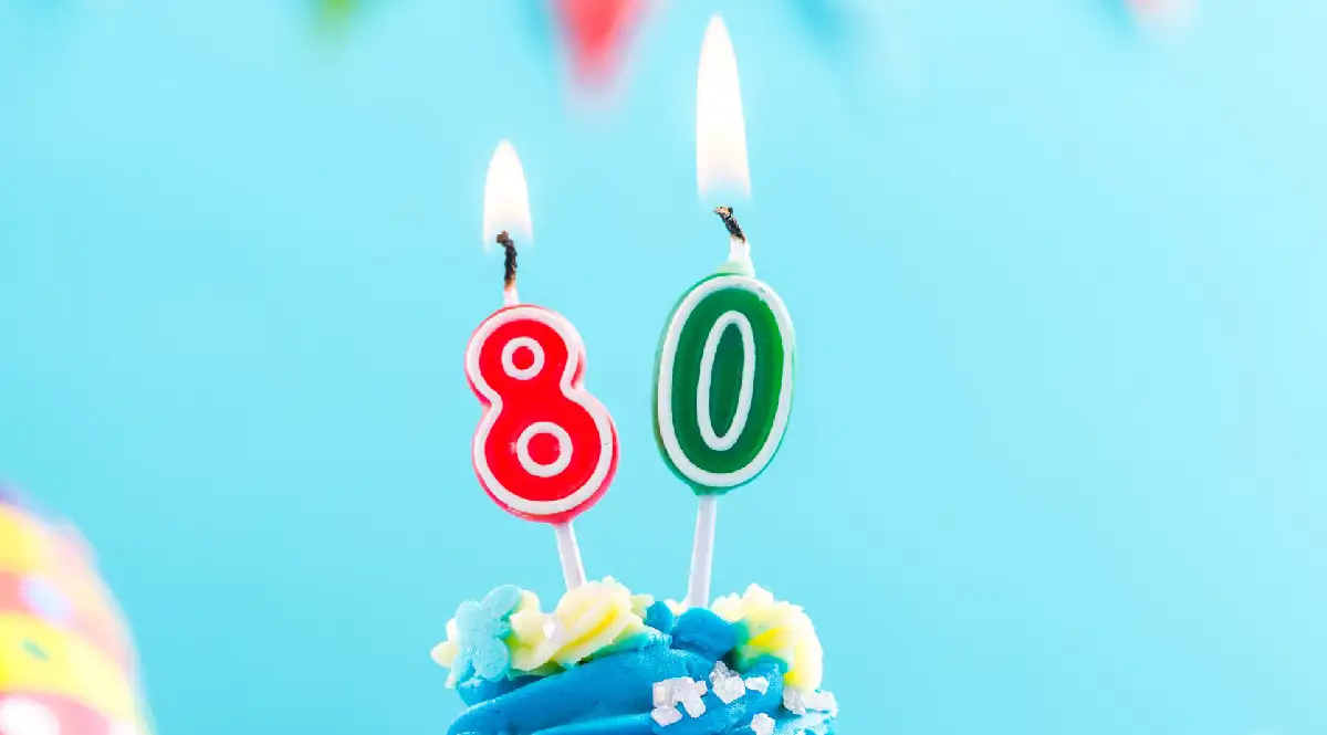 Blauer Cupcake mit Kerze 80 und bunte Streusel, als Vorlage für Einladungskarten Geburtstag