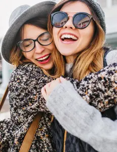 Zwei Frauen umarmen sich und lachen