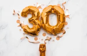 Sektflasche mit Luftballons als Zahl 30 und Konfetti als lustige Idee für Einladungen runden Geburtstag