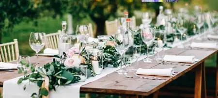Elegant gedeckter Tisch mit Tischdeko aus Blättern, Gold Aktzenten und Gläsern