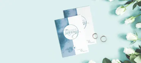 Romantische Hochzeitskarten als Einladungsarten für die Kirchliche Hochzeit, in Blau weiß auf blauem Tisch