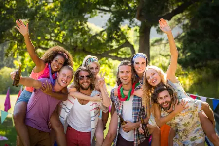 Gruppe von jungen Erwachsenen lächelt in Kamera, Jugendliche feiern Geburtstag, tragen bunte coole Kleidung