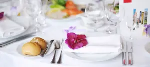 Elegante Tischdeko mit Tischdeko in Weiß mit mit Blüten.