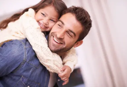 Ein Dad mit seiner Tochter auf den Schultern, beide lachen