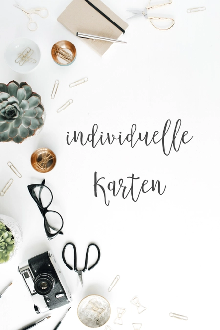 Schwarzer eleganter Schriftzug "Individuelle Karten" auf weißem Hintergrund mit goldener Schüssel und weiteren Accessoires
