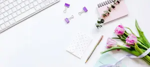 Tisch mit Laptop, Blumen und Umschlag für Einladungskarten zur Hochzeit