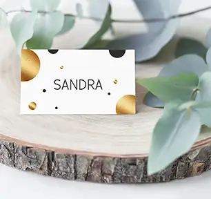 Tischkarte zum Geburtstag oder Hochzeit, beschriftet mit "Sandra" auf weißem Hintergrund mit goldenen und schwarzen runden Kreisen