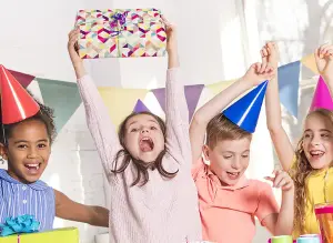 Kindergeburtstag mit lustigen Kindern. Cooler Junge und süße Mädchen. Bunte Geschenke und Kuchen, Gutes Motiv für Einladung zum Geburtstag
