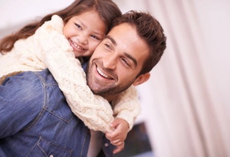 Ein Dad mit seiner Tochter auf den Schultern, beide lachen