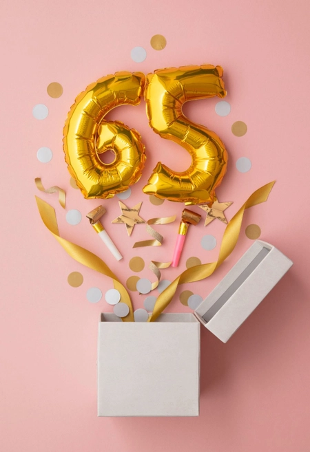 Goldene 65 als Ballon springt aus Geschenkbox, rosa Hintergrund, Motiv für Einladung zum Geburtstag