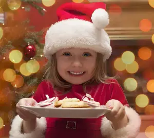 Kind zu Weihnachten mit Keksen als Vorlage für Menükarten Weihnachten