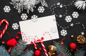 Weihnachtsgrüße geschäftlich auf weißer Karte, Foto ist dekoriert mit Schneeflocken und Süßigkeiten und Tannenzweigen