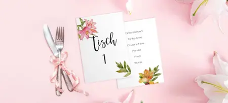 Platzkarten Hochzeit in weiß mit Blumen in Gold auf rosa Tisch neben Besteck
