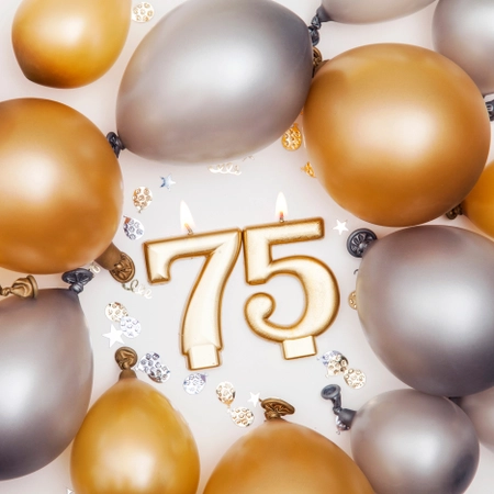 Brennende golde Kerze als zahl 75, runde goldene und silberne Ballons drumherum, als Vorlage für Einladung zum Geburtstag