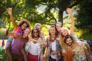 Gruppe von jungen Erwachsenen lächelt in Kamera, Jugendliche feiern Geburtstag, tragen bunte coole Kleidung
