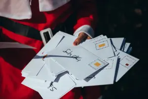 Weihnachtsmann hält Weihnachtskarten und Grußkarten in der Hand