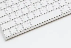 Weißer Schreibtisch mit weißer Tastatur, verschiedene Briefumschläge für Partyeinladungen - Motive lassen sich individuell bedrucken mit Einhorn, Meerjungfrau, Pferden, Regenbogen oder Herzen