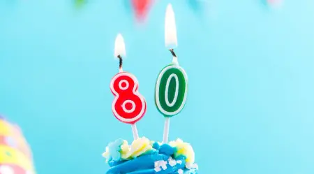 Blauer Cupcake mit Kerze 80 und bunte Streusel, als Vorlage für Einladungskarten Geburtstag