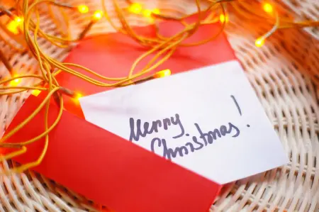 Weihnachtskarte im Korb mit Lichterkette und Schriftzug "Merry Christmas"