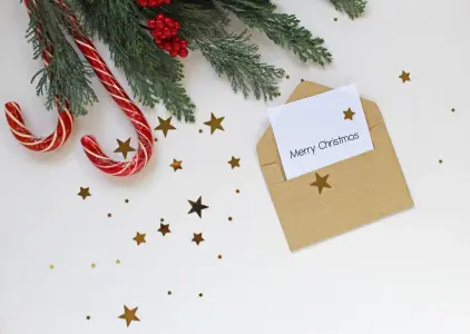 Klassische Weihnachtskarte im Umschlag als Grußkarte gestalten, Zweige und Zuckerstangen im Hintergrund