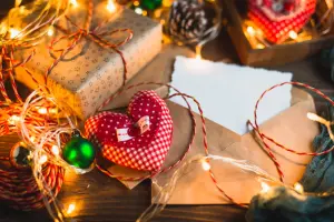 Weihnachtskarte in Weiß mit braunem Umschlag, Tisch zu Weihnachten mit Deko, Lichterkette und Geschenk