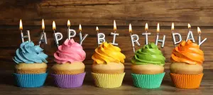 Drei Cupcakes mit Schriftzug "Happy Birthday" Kerzen als Einladung zum Geburtstag
