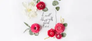 Dankeskarten Hochzeit mit Text als Postkarte auf einem weißen Tisch. Rote Rosen umrahmen das Vintage Schriftstück