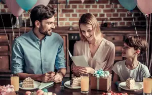 Geburtstag mit Kindern: Mutter erhält Einladungskarten zum Geburtstag, bunter Geburtstagstisch mit Geschenk, lustige Deko. Geburtstagseinladungen mit Umschlägen in A6 bestellen