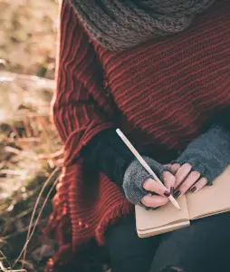 Frau mit Stift und Notizbuch, Schreiben bei Trauer