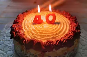 Einladung zum 40. Geburtstag der Kuchen mit brennenden Kerzen in Form der zahl 40 wartet schon