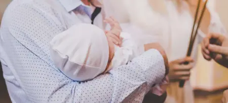 Baby auf dem Arm zur Taufe