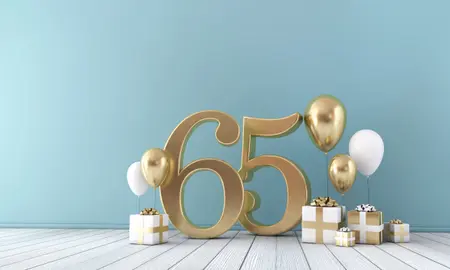 Goldene 65 steht vor Wand in mint, goldene und weiße Geschenke und runde Ballons