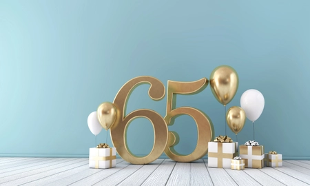 Goldene 65 steht vor Wand in mint, goldene und weiße Geschenke und runde Ballons