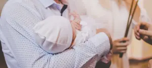 Baby auf dem Arm zur Taufe