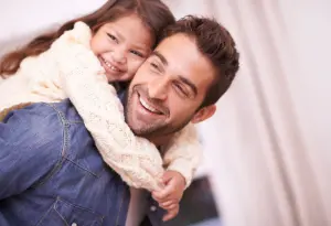 Ein Dad mit seiner Tochter auf den Schultern, beide lachen