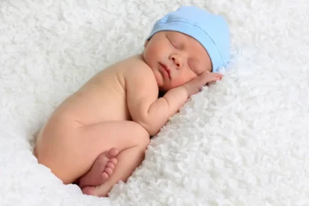 Schlafendes Baby mit blauer Mütze