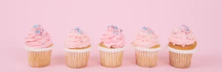 Cupcakes am 1. Geburtstag für die Babyparty auf rosa Hintergrund