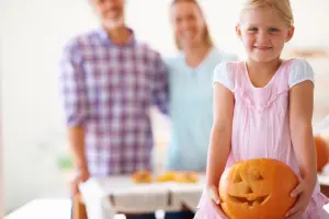 Kind bastelt einen Halloweenkürbis