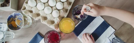 Ostereier färben mit Pinsel und Farbe. Viele bunte und weiße Eier bemalen