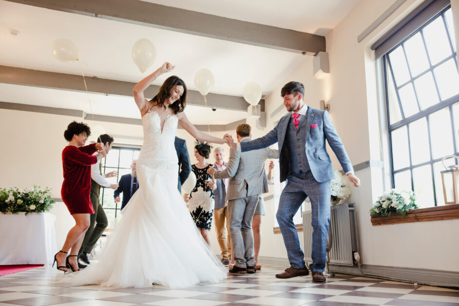 Hochzeitsparty, Brautpaar und Gäste tanzen
